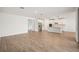 Spacious open-concept living area with wood look tile flooring leading into kitchen at 1775 Draughton Dr, Zephyrhills, FL 33541