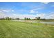 Expansive backyard with green grass and a tranquil pond view at 1806 Draughton Dr, Zephyrhills, FL 33541