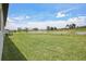 A large backyard with well-kept grass and a tranquil pond in the distance at 1806 Draughton Dr, Zephyrhills, FL 33541