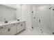 Bright bathroom featuring double vanity sinks, a spacious walk-in shower with glass door, and modern fixtures at 1806 Draughton Dr, Zephyrhills, FL 33541