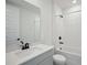 Modern bathroom with white tile, quartz countertops and dark fixtures at 1806 Draughton Dr, Zephyrhills, FL 33541