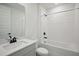 Modern bathroom with white tile, quartz countertops and dark fixtures at 1806 Draughton Dr, Zephyrhills, FL 33541