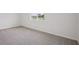 A light and airy bedroom with gray carpeting and a large window to let the sunshine in at 1806 Draughton Dr, Zephyrhills, FL 33541