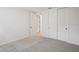 A simple bedroom with gray carpeting, white walls and closet, and a doorway into another room at 1806 Draughton Dr, Zephyrhills, FL 33541