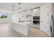 Spacious kitchen island with stainless steel appliances, shaker cabinets, and a view to the outdoors at 1806 Draughton Dr, Zephyrhills, FL 33541