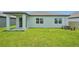 Home's rear elevation showing the freshly cut lawn and covered patio, creating an inviting outdoor space at 1817 Draughton Dr, Zephyrhills, FL 33541