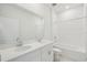 Bright bathroom featuring a double sink vanity with white cabinets and a shower over tub with white tile surround at 1817 Draughton Dr, Zephyrhills, FL 33541