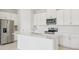 Modern kitchen with stainless steel appliances, white cabinets and a center island at 1817 Draughton Dr, Zephyrhills, FL 33541