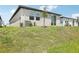 Backyard view with a modern home featuring large windows and a sliding glass door at 3539 Moscato Dr, Brooksville, FL 34602