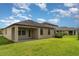 Exterior rear view of single story home with neutral paint, covered patio and yard at 13244 Satin Lily Dr, Riverview, FL 33579