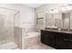 Elegant bathroom featuring a double vanity, a soaking tub, and a separate glass-enclosed shower at 13244 Satin Lily Dr, Riverview, FL 33579