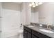 Bathroom featuring a double vanity with granite countertop and white tiled tub at 13244 Satin Lily Dr, Riverview, FL 33579