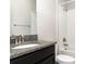 Bathroom featuring a granite countertop with modern fixtures and white tiled tub at 13244 Satin Lily Dr, Riverview, FL 33579