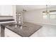 Kitchen island with sink, granite countertop, and stainless steel dishwasher overlooking the living spaces at 13244 Satin Lily Dr, Riverview, FL 33579