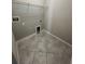 Tiled laundry room with dryer connection, washer connection, and wire shelving at 13244 Satin Lily Dr, Riverview, FL 33579