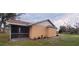 Home's back exterior featuring a screened patio area, landscaping, and a well-manicured lawn at 1835 Rival Ter, North Port, FL 34286