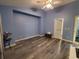 Well-lit bedroom with modern gray flooring, blue painted walls, and a stylish ceiling fan at 1835 Rival Ter, North Port, FL 34286