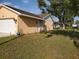 A side view of the home showcasing a well-maintained yard, exterior features, and home entry at 1835 Rival Ter, North Port, FL 34286