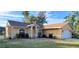 Charming single-story home with arched windows, beautiful landscaping, and a well-maintained lawn at 1835 Rival Ter, North Port, FL 34286