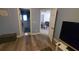Living room with wood floors leading to the bathroom and dining room with an open door at 1835 Rival Ter, North Port, FL 34286