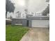 Exterior view of a single-story home with an attached garage, driveway, and lawn at 3805 N Cranberry Blvd, North Port, FL 34286