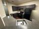 Kitchen with dark cabinets, black appliances, and laminate countertops with stainless steel sink at 3805 N Cranberry Blvd, North Port, FL 34286