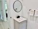 Updated bathroom featuring a modern vanity, round mirror, and stylish fixtures at 38706 8Th Ave, Zephyrhills, FL 33542