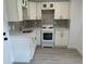 Well-lit kitchen with bright white cabinetry, stainless steel fixtures, and light countertops at 38706 8Th Ave, Zephyrhills, FL 33542