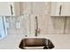 Close-up of a kitchen sink featuring stylish faucet, white countertops, and subway tile backsplash at 38706 8Th Ave, Zephyrhills, FL 33542