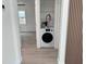 View of a stackable washer and dryer setup with shelf, shelving, and nearby bedroom at 38706 8Th Ave, Zephyrhills, FL 33542