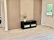 Open living room showcasing wood paneling, modern flooring, and a stylish entertainment center at 38706 8Th Ave, Zephyrhills, FL 33542
