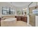 Bathroom featuring a soaking tub, walk-in shower and dark wood cabinetry at 5531 Arnie Loop, Bradenton, FL 34211