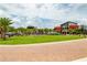A view of the community common area with lush green spaces, palm trees, and inviting recreational facilities at 42862 Park View Dr, Punta Gorda, FL 33982