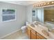 Bathroom featuring a double sink vanity, tile flooring, large mirror, and a window at 10429 Avelar Ridge Dr, Riverview, FL 33578