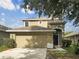 Two-story home with a two-car garage, arched entryway and landscaped front yard against a blue sky at 10429 Avelar Ridge Dr, Riverview, FL 33578
