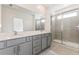 Bathroom featuring double vanity sinks, framed mirror, and a glass enclosed shower at 17322 Alderwood Ln, Punta Gorda, FL 33982