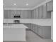 Modern kitchen boasts gray cabinets, island with white countertop, and stainless oven at 17322 Alderwood Ln, Punta Gorda, FL 33982