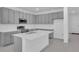 Modern kitchen boasts gray cabinets, island with white countertop, and stainless oven at 17322 Alderwood Ln, Punta Gorda, FL 33982