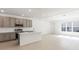 Open-concept kitchen and living area with modern appliances and ample natural light from large windows at 17322 Alderwood Ln, Punta Gorda, FL 33982