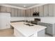 Bright kitchen featuring modern gray cabinets, stainless appliances, and a center island with sink at 17322 Alderwood Ln, Punta Gorda, FL 33982