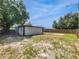 Wide backyard featuring a white block building, partial fence, and blue sky at 5001 S 88Th St, Tampa, FL 33619