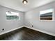Minimalist bedroom with hardwood floors, bright natural light, and two large windows, creating a serene atmosphere at 5001 S 88Th St, Tampa, FL 33619