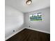 Bedroom features hardwood floors, white walls, and a window overlooking trees at 5001 S 88Th St, Tampa, FL 33619