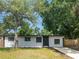 Charming one-story home featuring a freshly painted exterior, mature shade trees, and a new concrete driveway at 5001 S 88Th St, Tampa, FL 33619