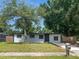 Street view of a beautifully renovated white brick single Gathering home featuring mature shade trees and a mailbox at 5001 S 88Th St, Tampa, FL 33619