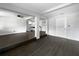 Open-concept living space featuring dark wood floors, exposed beams, and view into updated kitchen at 5001 S 88Th St, Tampa, FL 33619