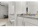 Bathroom with dual sinks, granite countertops, white cabinets, and connecting room views at 8297 Ivy Stark Blvd, Wesley Chapel, FL 33545