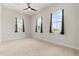 A bright bedroom with neutral carpet has three windows providing an abundance of light at 8297 Ivy Stark Blvd, Wesley Chapel, FL 33545