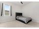 Cozy bedroom with carpet, window, black headboard, and gray striped bedding at 8297 Ivy Stark Blvd, Wesley Chapel, FL 33545
