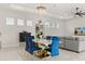 Dining area features a marble dining table with blue velvet chairs and an elegant chandelier at 8297 Ivy Stark Blvd, Wesley Chapel, FL 33545